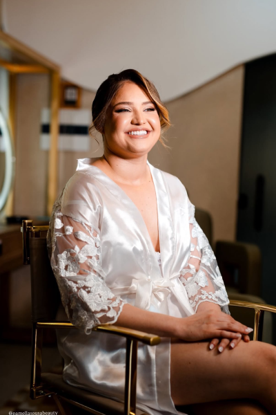 Noiva sorridente de robe branco com maquiagem e penteado prontos
